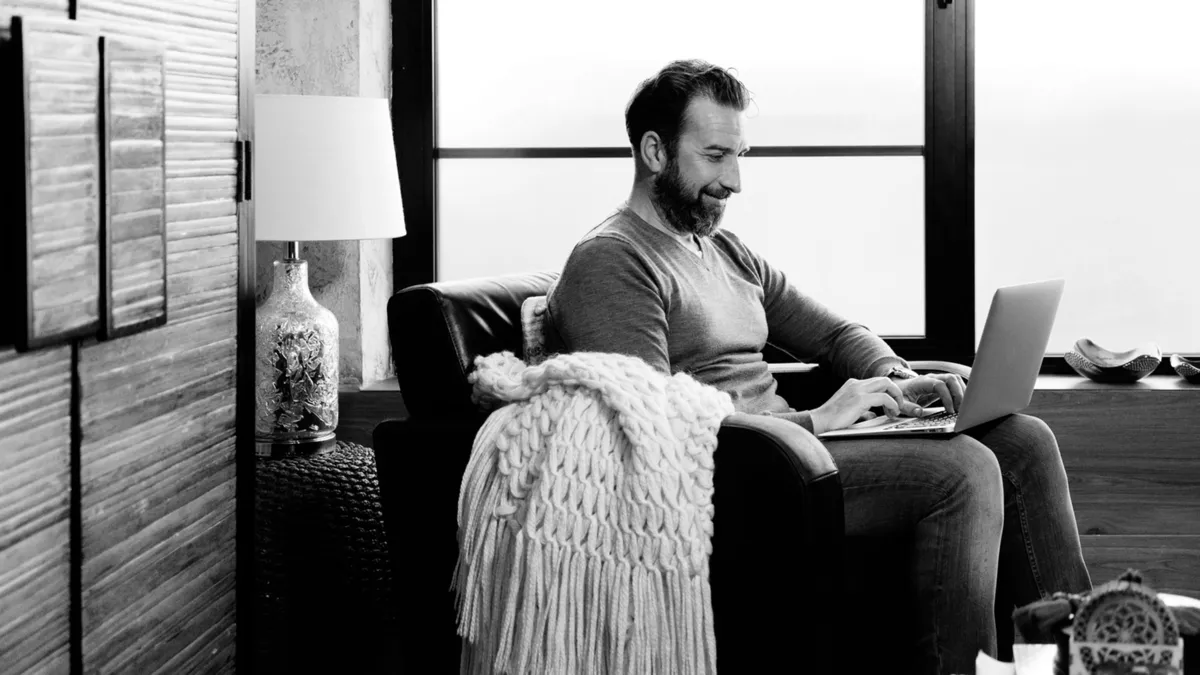 Mann sitzt zufrieden vor seinem PC Headerbild GoldDepot